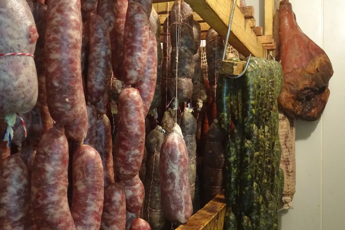 Saucissons, diots et jambon secs suspendus dans le séchoir de la ferme